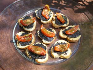Assiette avec tartines de tapenade d'olives noires et morceaux de tomates séchées