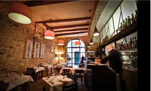 Vue de l'intérieur du restaurant le Pastis. Décor sobre, lumière tamisée et chaude