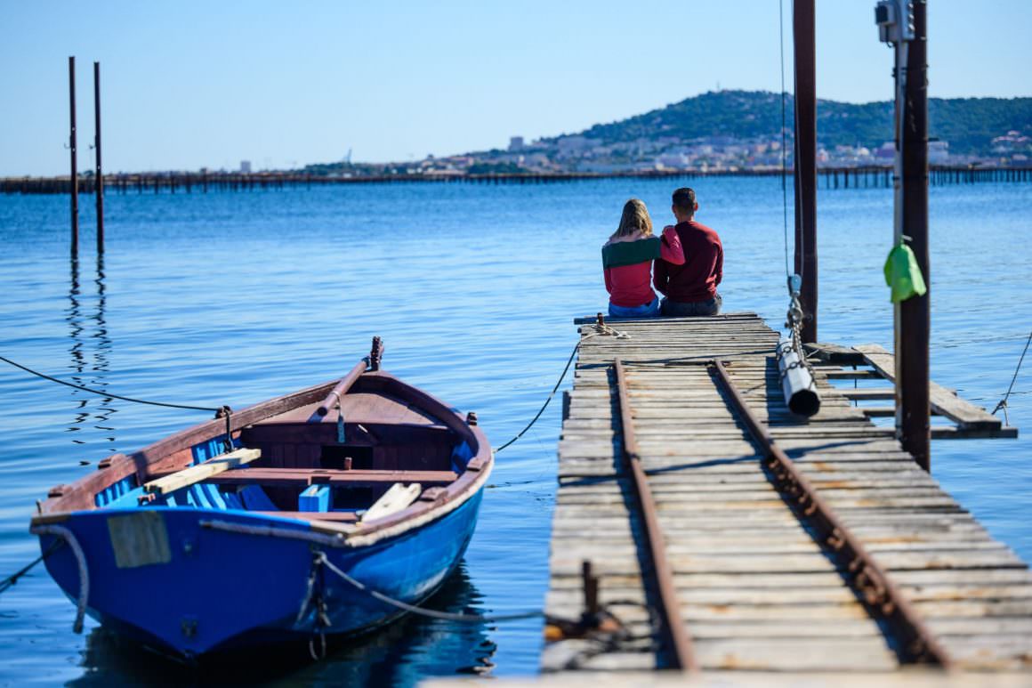 Couple au bout d'un ponton dans un mas conchylicole face à Sète et aux parcs à huîtres