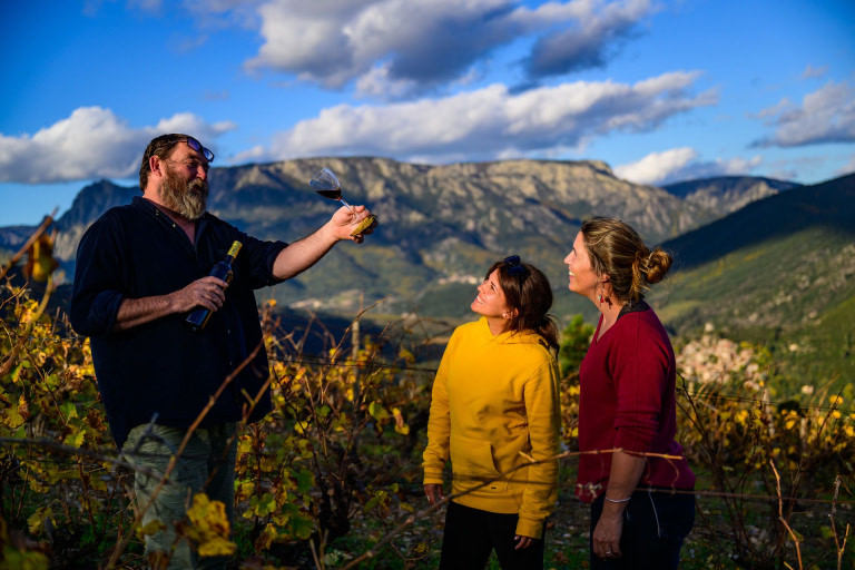 2 jeunes femmes qui assistent à une dégustation de vin avec un vigneron dans le Vignoble de Berlou