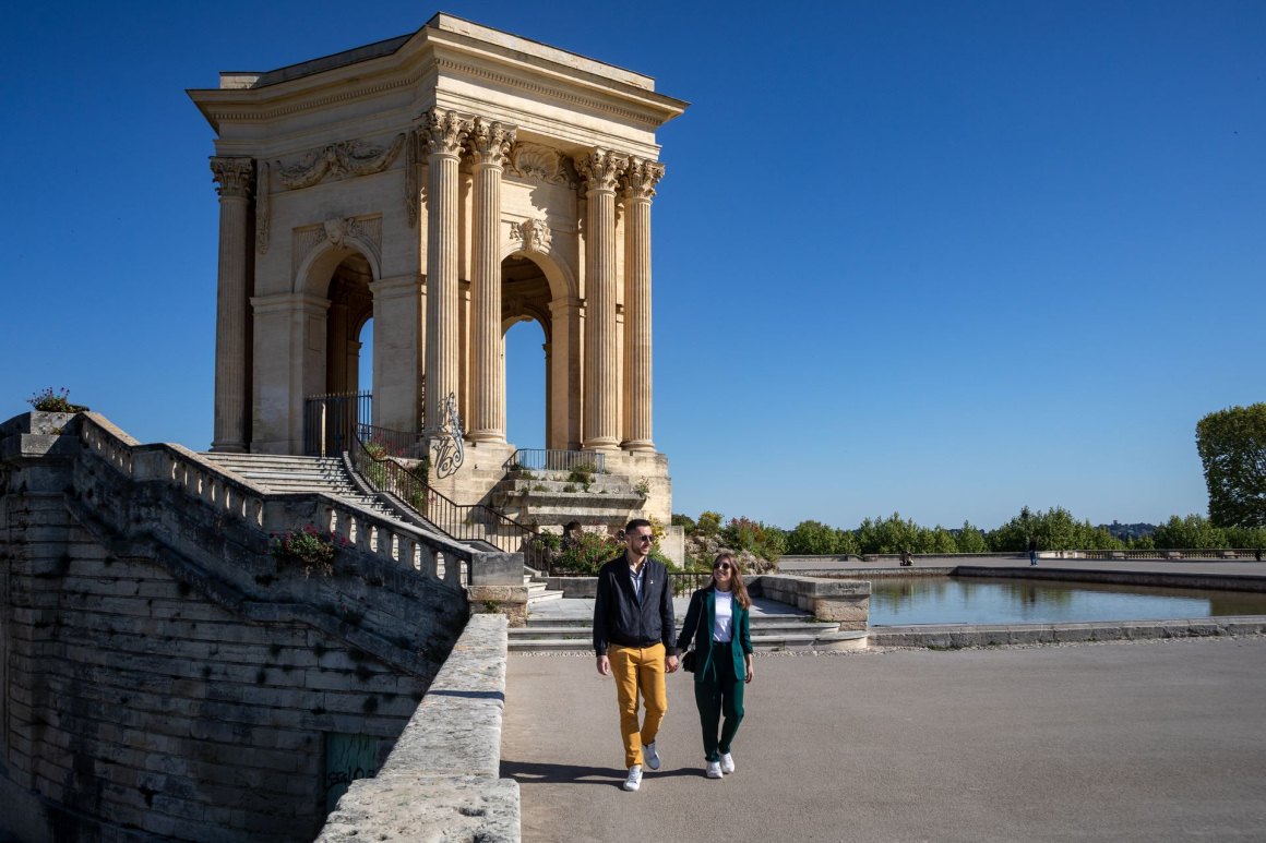 jeune couple qui se balade devant le Château d'eau du Peyrou à Montpellier