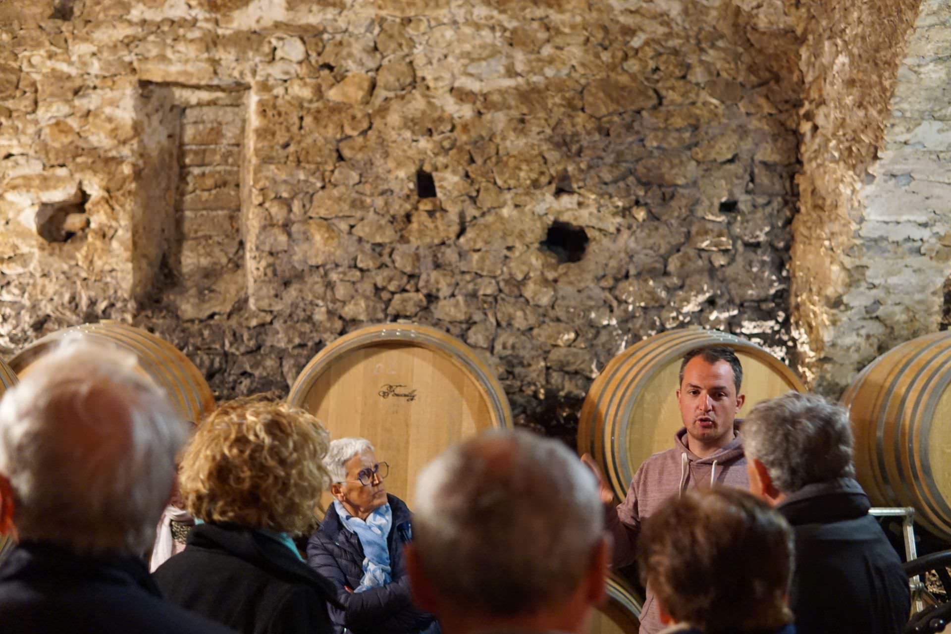 Des personnes visitent le chai du Domaine de Brunet au Causse de la Selle sous la houlette de Louis Coulet, le vigneron