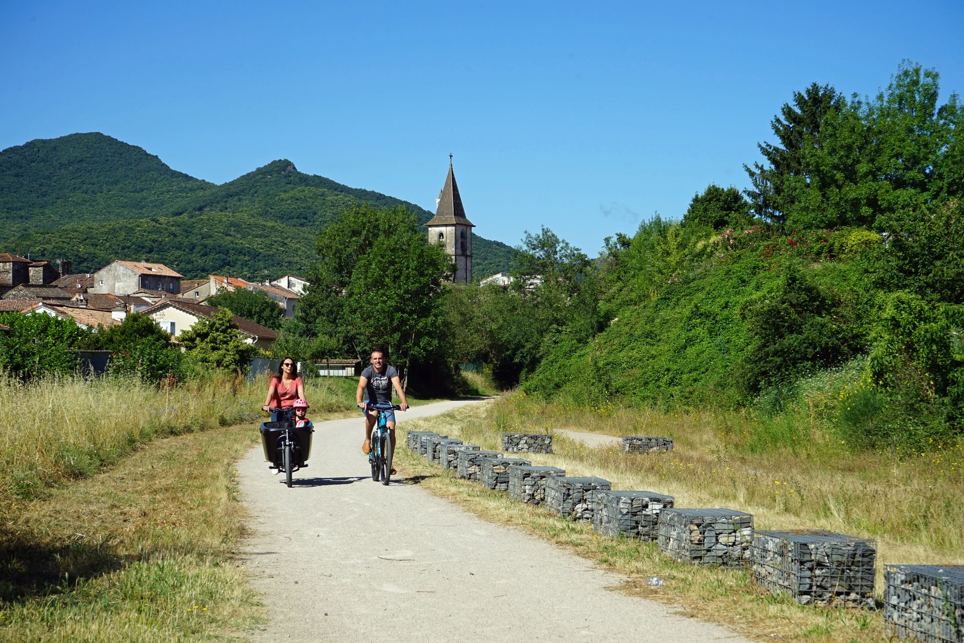 Une famille se balade en VTC sur la voie verte Passa Païs dans le Haut-Languedoc