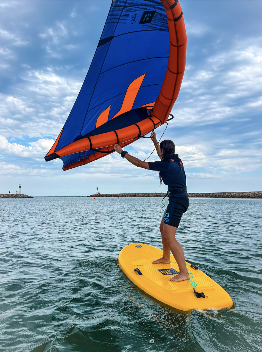 Fille en train de faire du wingfoil dans la Méditerranée