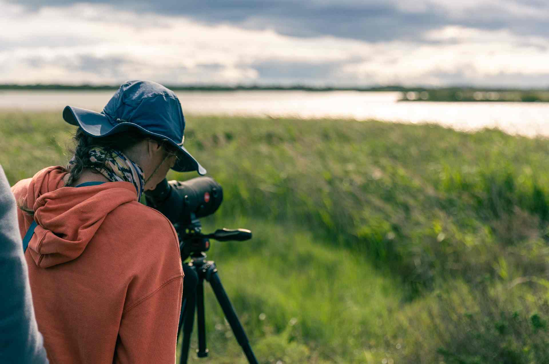 Dame qui observe les oiseaux à la jumelle à la Réserve du Bagnas