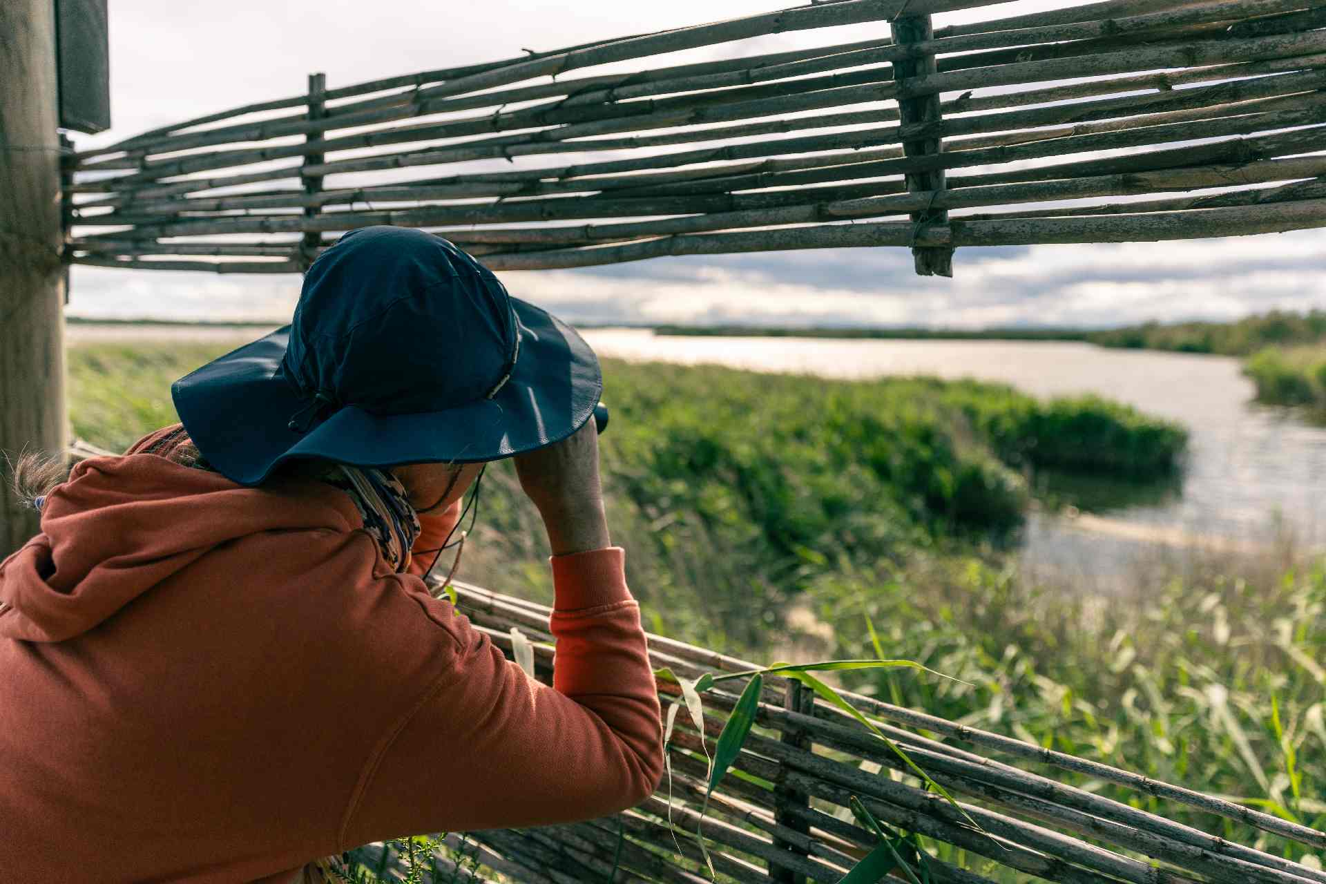 Dame qui observe les oiseaux à la jumelle à la Réserve du Bagnas