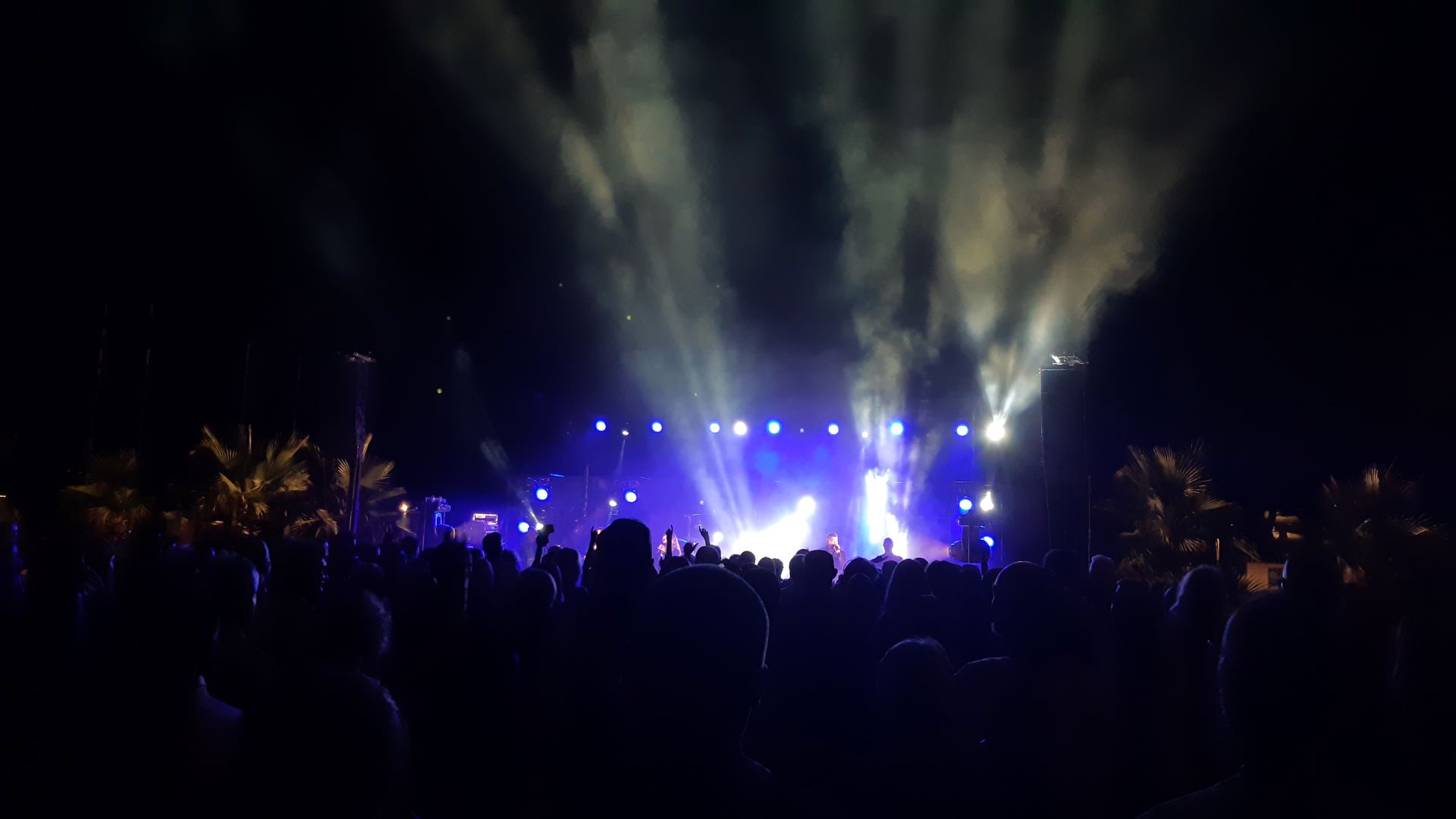 Soirée avec des personnes qui dansent. Un arrière plan avec des lumières bleues mauves avec des spots lumineux jaunes.