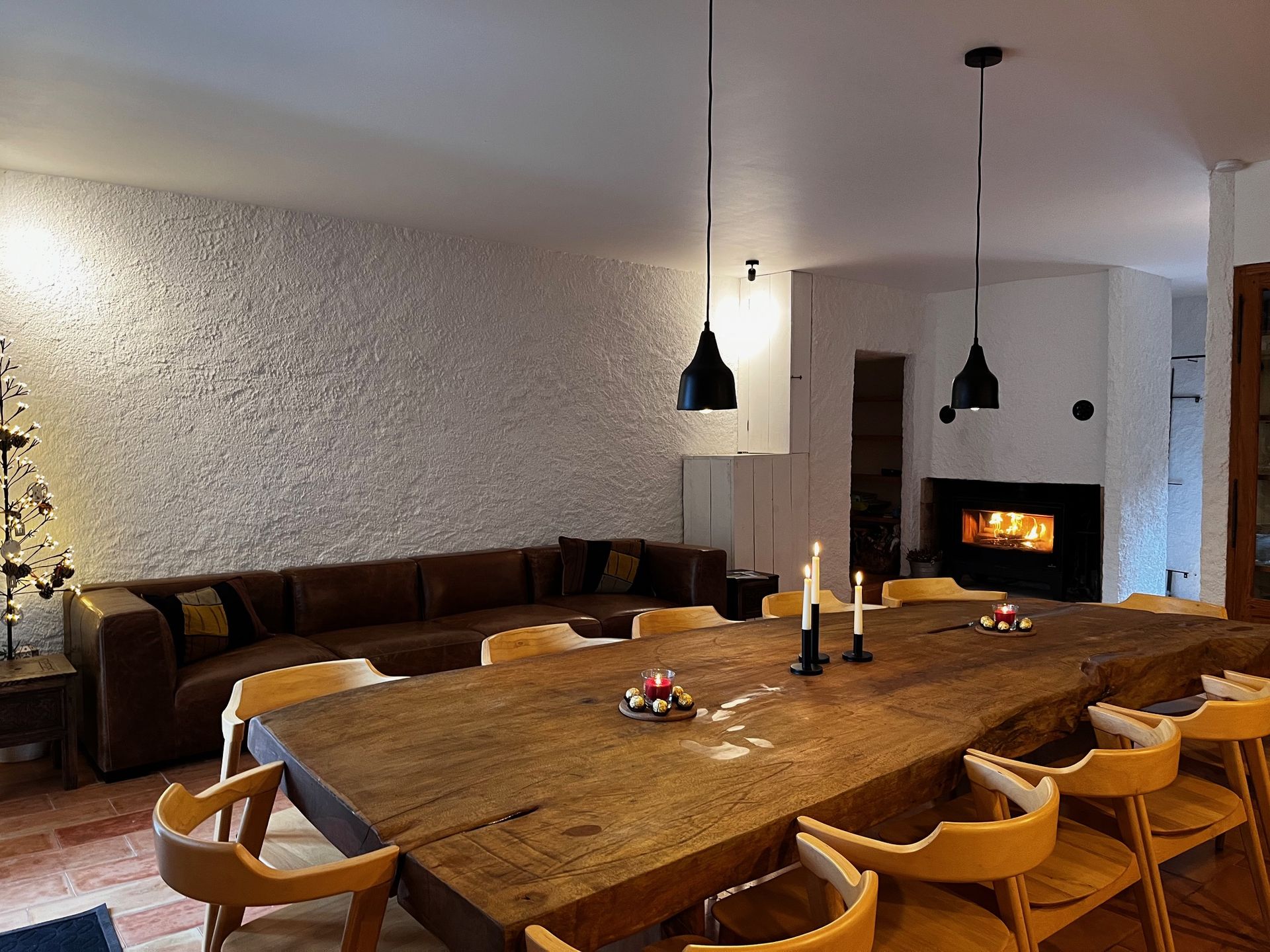 Vue sur le salon salle à manger de l'éco-gîte La Grange, avec son feu de cheminée qui crépite