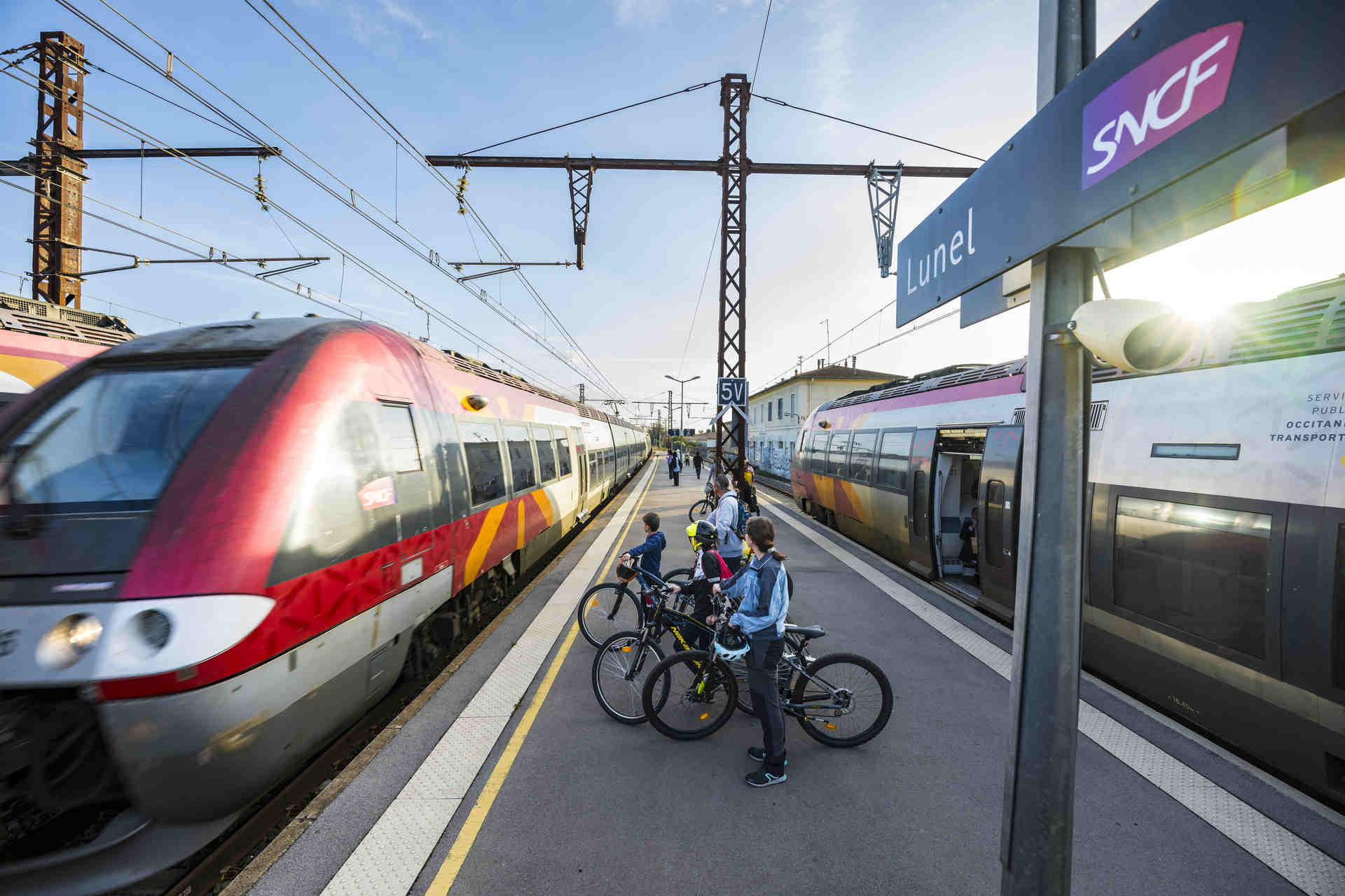 Famille qui attend le train avec des vélos en gare de Lunel