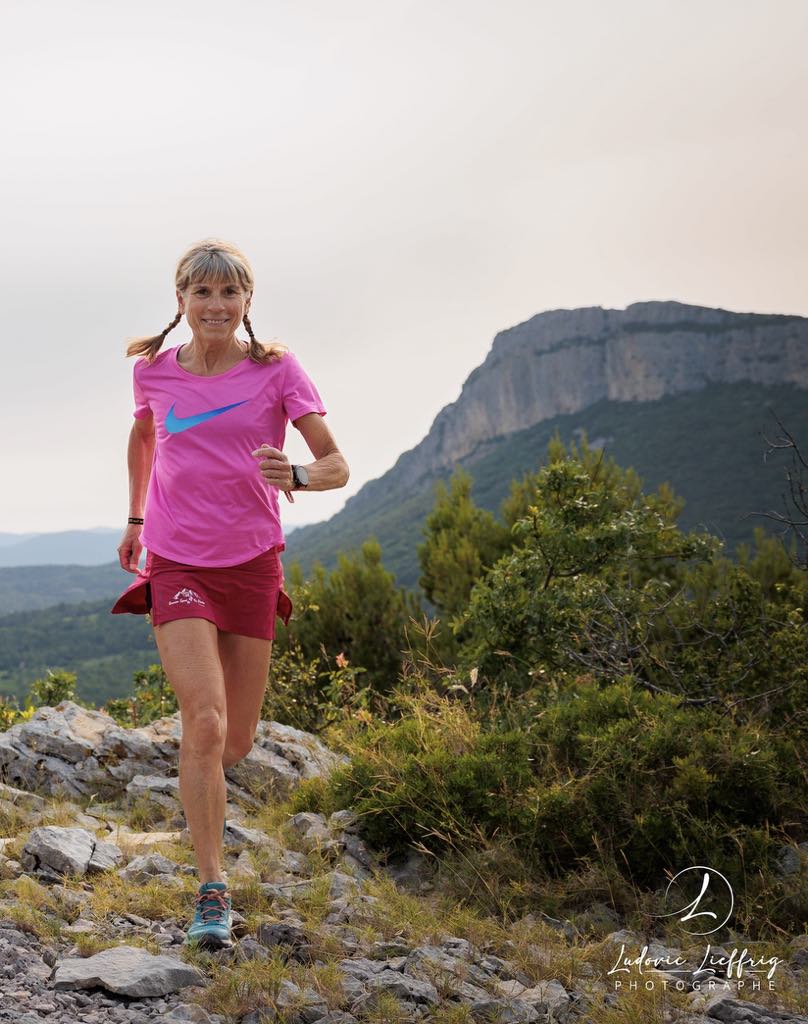 Françoise qui court un trail avec le pic st loup en arrière plan