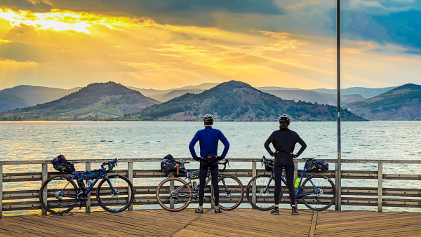 pratiquants de gravel bike sur la GTMC, admirant le coucher de soleil sur le lac du Salagou