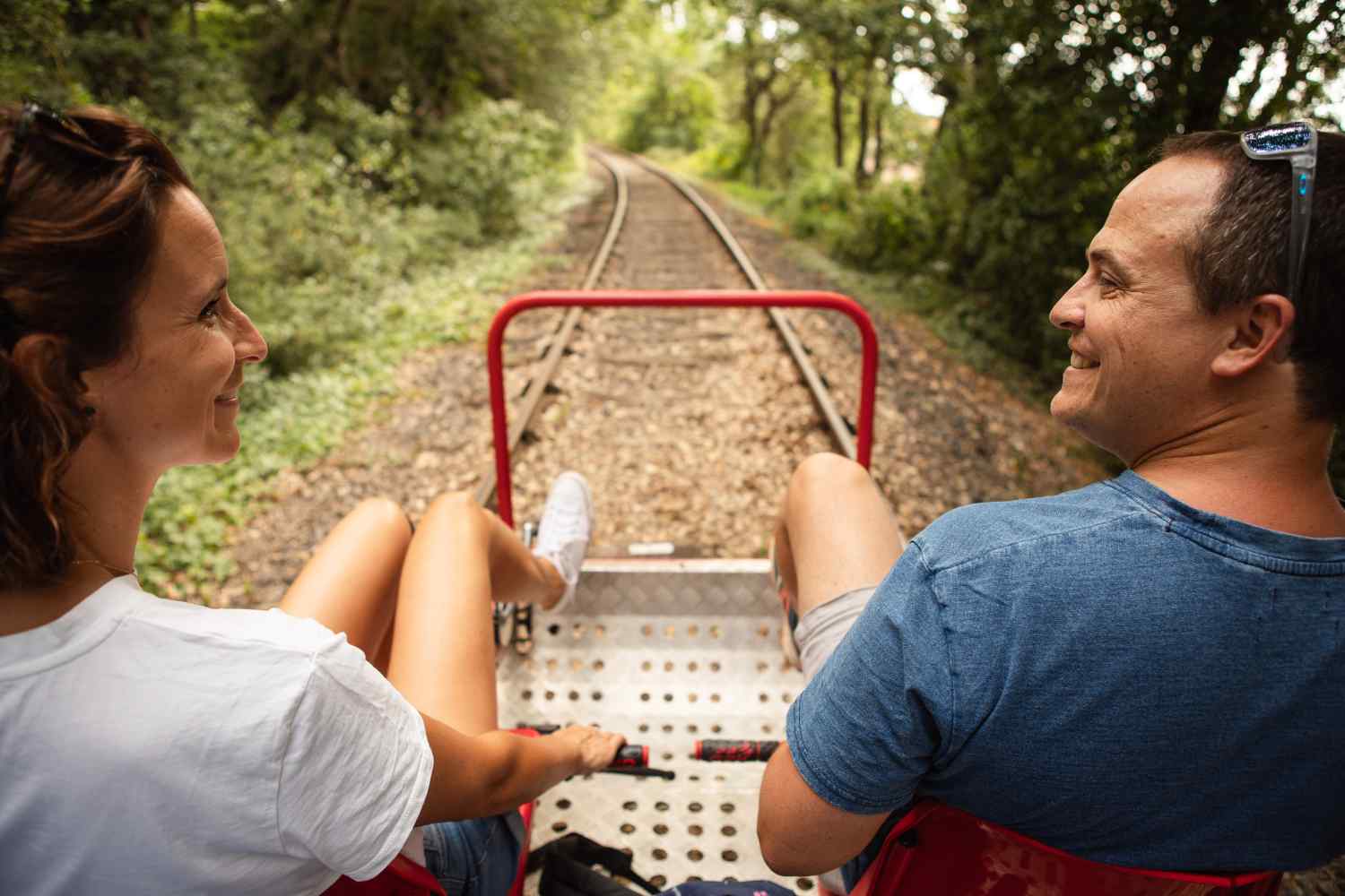 Un couple se balade en pédalorail sur une ancienne voie ferrée