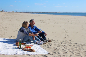 Couple de jeuniors qui pique-nique sur la plage de la Grande Motte