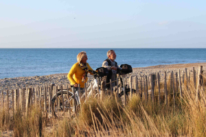 Couple de jeuniors en vélo à la plage de Villeneuve les Maguelone